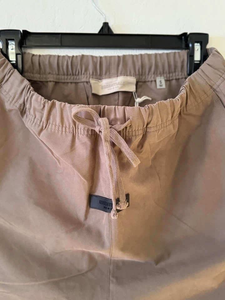 Essentials Fear of God Men’s Taupe Jogger Trousers, featuring Black Essentials Logo and Adjustable Drawstring Waist